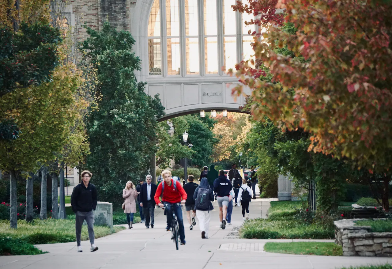 Students walking through an archway on a university campus